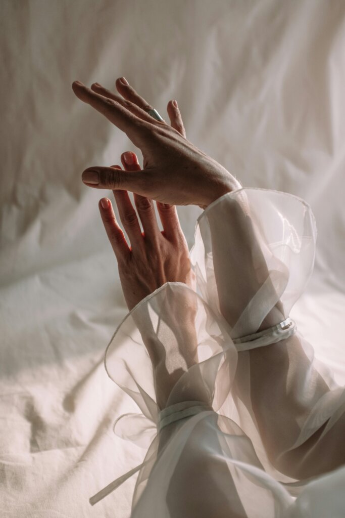 pexels-photo-4659810-4659810 A close-up of graceful hands wrapped in translucent silk fabric, showcasing elegance and creativity.