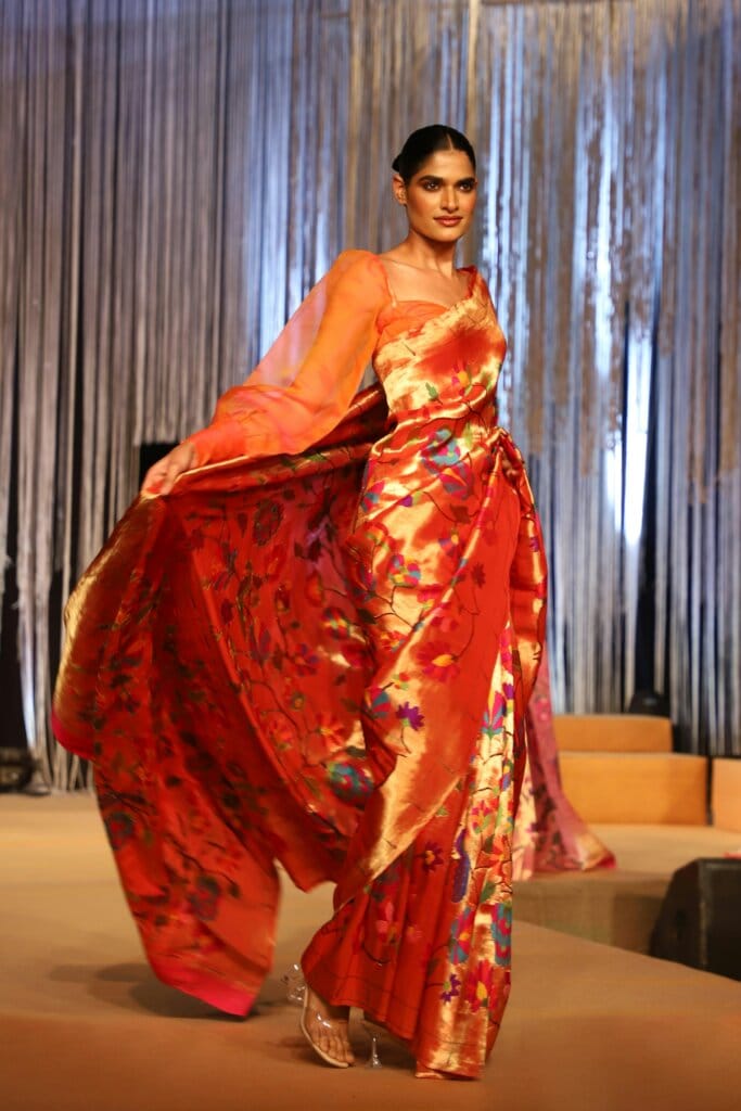 pexels-photo-12850280-12850280-1 Stunning model in vibrant traditional saree on runway. Captivating design and elegance.