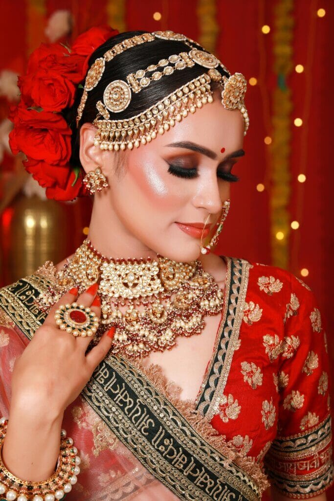 Close-up portrait of an Indian bride in traditional attire with ornate jewelry.