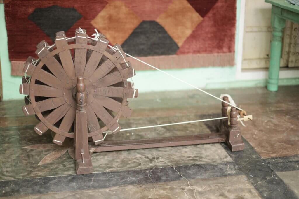 A classic spinning wheel on a rustic floor, perfect for textile and craft themes.